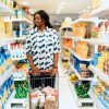 A woman enjoying grocery shopping in a vibrant Lagos supermarket aisle.